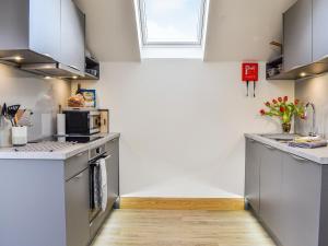 a kitchen with white walls and stainless steel appliances at The Old Mill in Fettercairn