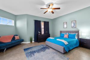 Dormitorio azul con cama y sofá en 116 Mediterranean Way, en Indian Harbour Beach 32 fotos más