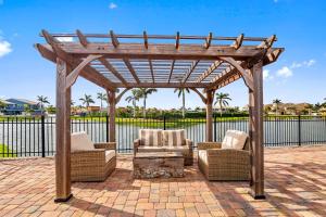 pérgola de madera con 2 sillas y mesa en 116 Mediterranean Way, en Indian Harbour Beach