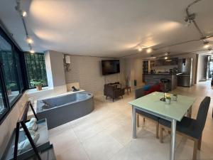 Estación El SaltoApartamento de lujo Poblado的厨房以及带浴缸和桌子的客厅。