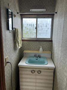 a small bathroom with a sink and a window at Rom's Inn in Wakimachi +31 photos