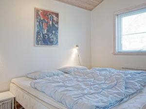 a bed in a bedroom with a painting on the wall at Idyllic Cottage in Allinge - By Traum Ferienwohnungen in Allinge +14 photos
