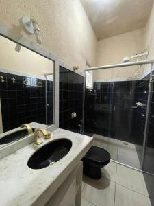 a bathroom with a sink and a shower and a toilet at Pitbox in Formiga