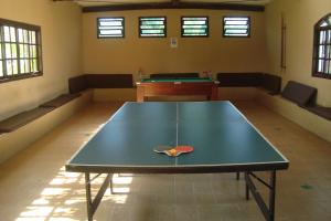 a ping pong table in the middle of a room with a pool table at Samburá Chalés in Ilha Comprida