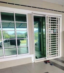 two windows on a building with a view of a street at Stingless Bee Homestay in Kluang