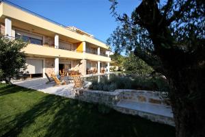 a house with a patio and a yard at Villa Fora Hvar in Hvar