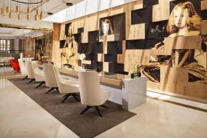 a restaurant with a long table and white chairs at Palacio de los Duques Gran Meliá - The Leading Hotels of the World in Madrid