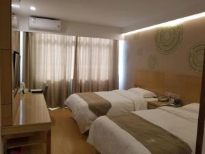 a hotel room with two beds and a television at GreenTree Inn Heze Changcheng Road Tianhua E-commerce Logistics Park Express Hotel in Heze