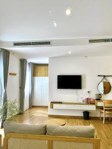 a living room with a couch and a flat screen tv at Triland Hotel in Phú Quốc