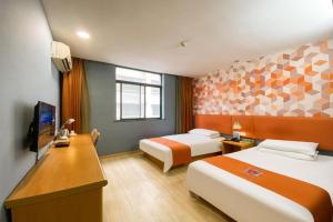 une chambre d'hôtel avec deux lits et un bureau dans l'établissement Pai Hotel Kunshan Youyi Hospital Qingyang South Road Branch, à Lujiabangzhan 172 autres photos