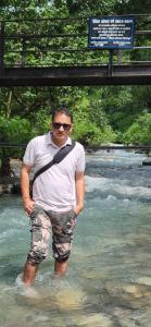 a man standing in the water in a river at dreamy orchard -myst in Nakraunda