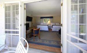 a door leading to a room with two beds at Colonial Inn Harbor Springs in Harbor Springs