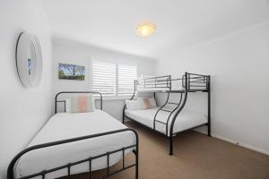 a bedroom with two bunk beds and a window at Riverside Retreat North Haven in North Haven