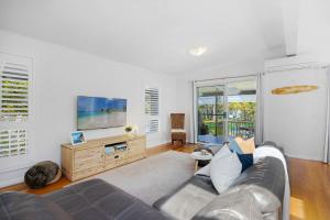 a living room with a couch and a flat screen tv at Riverside Retreat North Haven in North Haven