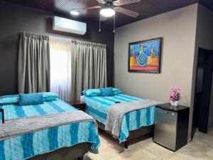 a bedroom with two beds and a ceiling fan at Gran Hostal Sula in San Pedro Sula +45 photos