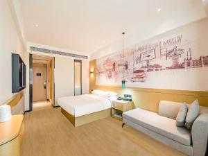 a hotel room with a bed and a couch at City Comfort Inn Zhaoqing Qixingyan Yihua Plaza Agile City in Zhaoqing