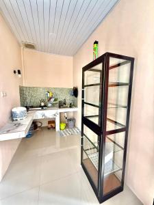 Habitación con escritorio y estante de cristal. en Villa Marlinda, en Narmada