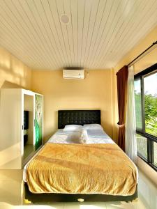 Un dormitorio con una cama grande en una habitación con ventana. en Villa Marlinda, en Narmada