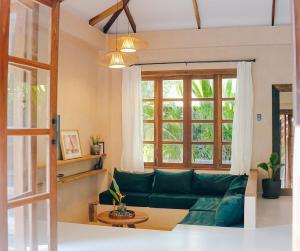 a living room with a green couch and a window at Marevka - Pool Villa with garden in General Luna