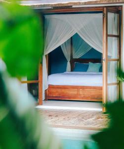 a bedroom with a bed with a canopy at Marevka - Pool Villa with garden in General Luna