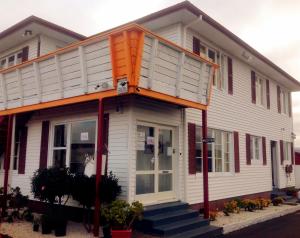 una casa blanca con techo naranja en Rainbow Motel en Tauranga