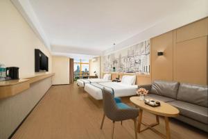 a hotel room with a bed and a couch at City Comfort Inn Nanning Exhibition Center Hangyang City Metro Station in Nanning