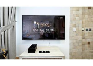 ein Bad mit einem TV an der Wand in der Unterkunft Al Reef Modern Escape -Sleek, Sunny & Serene in Abu Dhabi