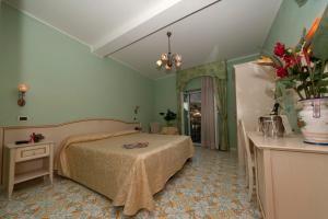 a bedroom with a bed and a vase of flowers at Hotel Villa Franca in Ischia +36 photos