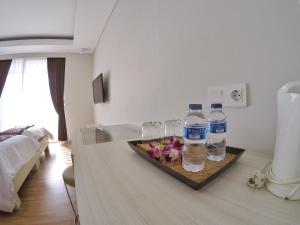 una camera con due bottiglie d'acqua e bicchieri da vino di Pondok Nyaman 15 a Denpasar