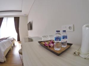 Habitación con 2 botellas de agua y copas de vino en Pondok Nyaman 15, en Denpasar