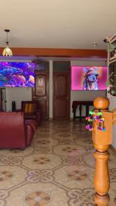 a living room with a flat screen tv and a couch at All Sur cusco in Cusco