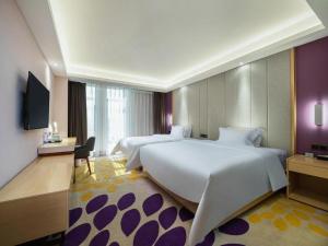 a hotel room with two beds and a television at Lavande Hotel Shanwei Haifeng Fenghuang New City Tianhong Plaza in Haifeng