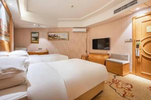 a hotel room with two beds and a flat screen tv at Vienna Hotel Qinghai Xining Wanda Plaza in Xining +106 photos