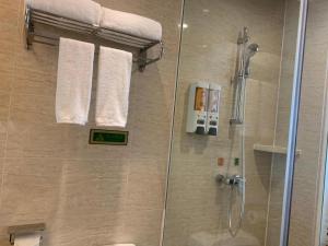 Un baño con ducha con puerta de cristal. en Vienna Hotel Shenzhen Window of the World Qiaochengdong Metro Station, en Shenzhen 208 fotos más