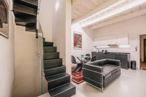 a staircase in a living room with a couch at Suite d'Art - Centro Storico di Arezzo in Arezzo