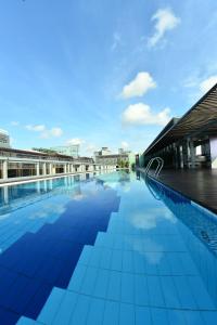 a large swimming pool with blue tiles on the side of a building at Hotel Chancellor@Orchard in Singapore