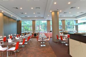 a dining room with tables and red chairs at Hotel Chancellor@Orchard in Singapore