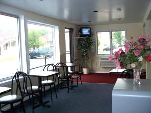 a dining room with tables and chairs and flowers at Budget Inn & Suites in Wall Township