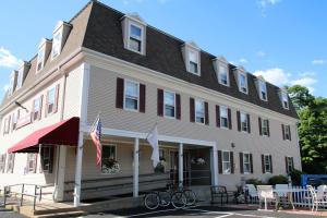 un gran edificio blanco con bicicletas estacionadas frente a él en Westborough Inn, en Westborough