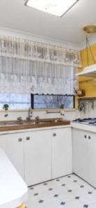 a kitchen with white cabinets and a window at Aeris Country Cottage in Junee +10 photos