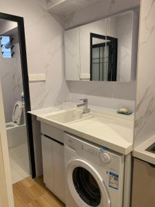 a bathroom with a washing machine and a sink at Ashely apartment 2 bedrrooms in Nadi