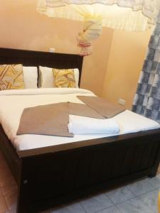 Una cama con una manta marrón. en Villa Serene Hotel Kitale, en Kitale