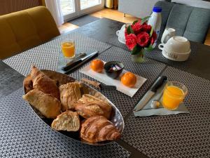 a table with a plate of bread and orange juice at Le Jolibardet in Vieillevigne