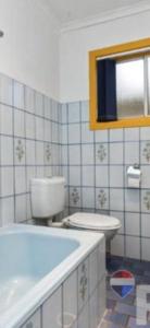 a bathroom with a tub and a toilet and a mirror at Aeris Country Cottage in Junee