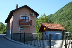 a small house with a fence in front of it at Bed & Fishing House in Slap ob Idrijci