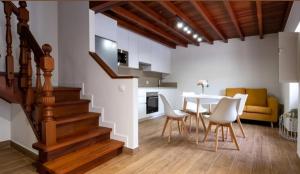 a kitchen and dining room with a staircase and a table and chairs at LolaPlayadeCarnota in Pedrafigueira