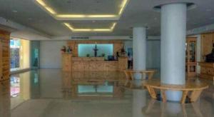 ein großer Raum mit Säulen und einem Altar in einem Gebäude in der Unterkunft Piyaporn Pavilion Hotel in Mae Sai