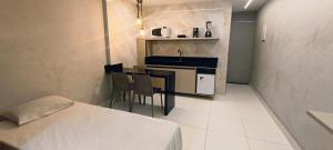 a small kitchen with a sink and a table at Victory Tambaú in João Pessoa +9 photos