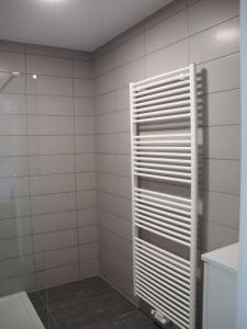 Baño de azulejos blancos con ducha acristalada en la puerta trasera en Karthuizer Zeezicht I, en Nieuwpoort 33 fotos más