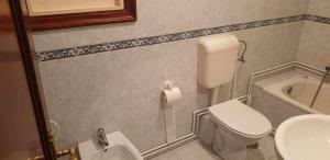 a bathroom with a toilet and a sink at Piso de Perlío, ideal para gente amante de la pla in Fene